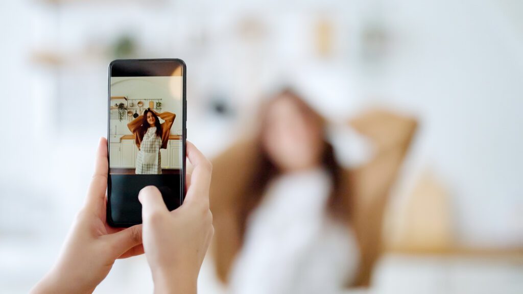 Young asian woman shooting together dancing in kitchen at house when making video for social media, stories trendy dance at home make online content